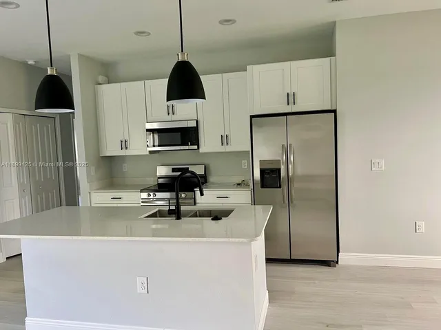a kitchen with stainless steel appliances a refrigerator sink and microwave