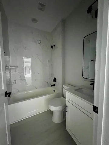 a bathroom with a granite countertop toilet a sink and bathtub