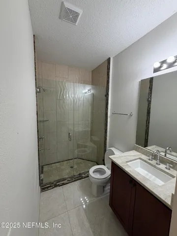 a bathroom with a granite countertop sink a toilet and shower