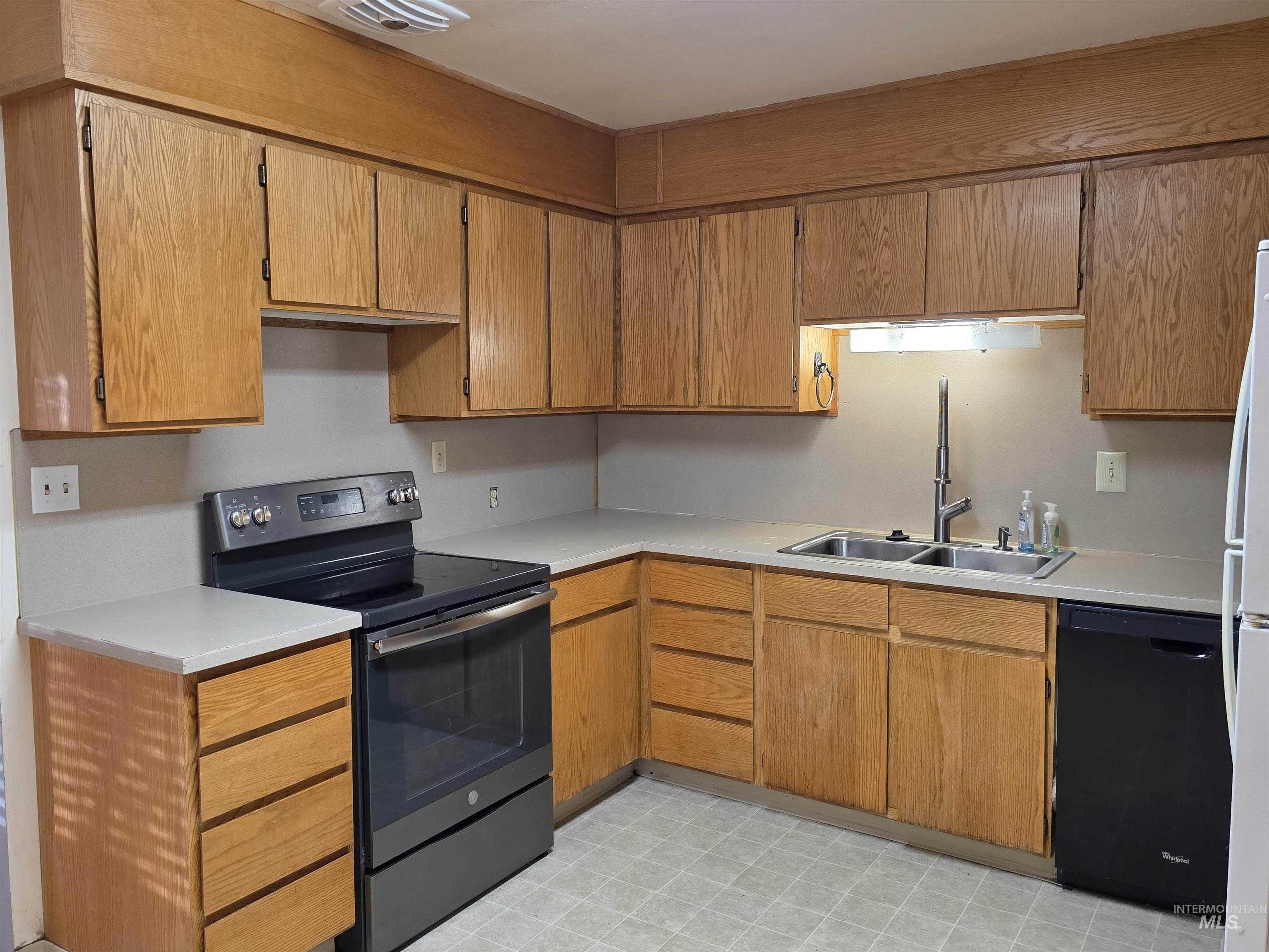 503 Oak Street Kamiah, ID 83536 - Photo 10 of 36 Kitchen with electric stove, dishwasher, light countertops, light floors, and brown cabinets