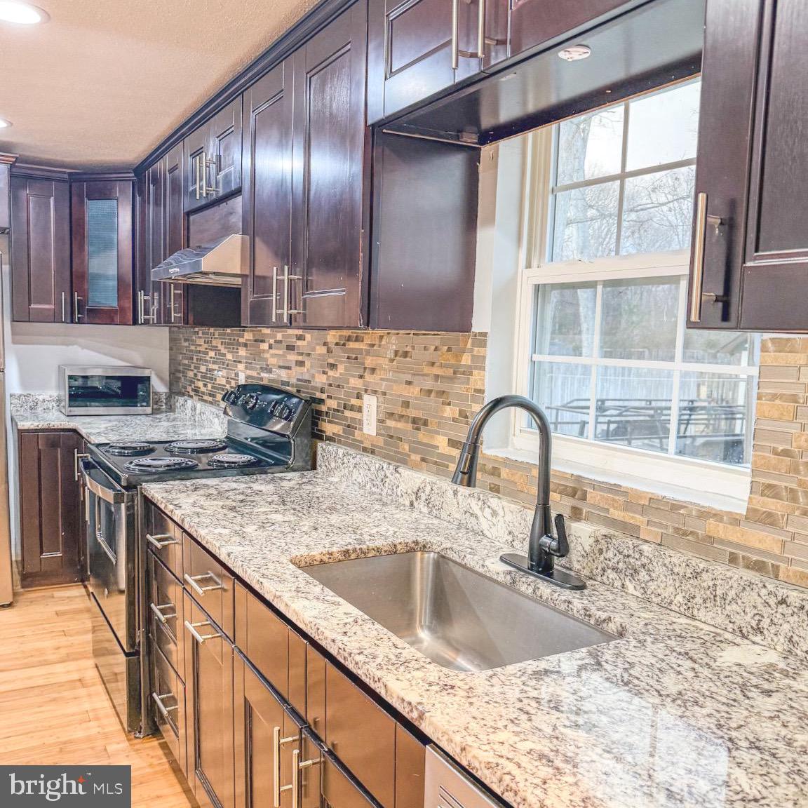 205 Biddle Road Accokeek, MD 20607 - Photo 21 of 31 a kitchen with granite countertop a sink a counter top space appliances and cabinets