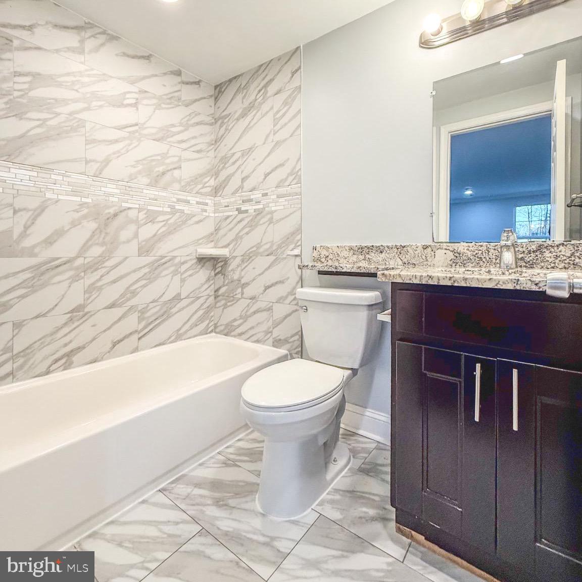 205 Biddle Road Accokeek, MD 20607 - Photo 30 of 31 a bathroom with a granite countertop toilet a sink and bathtub