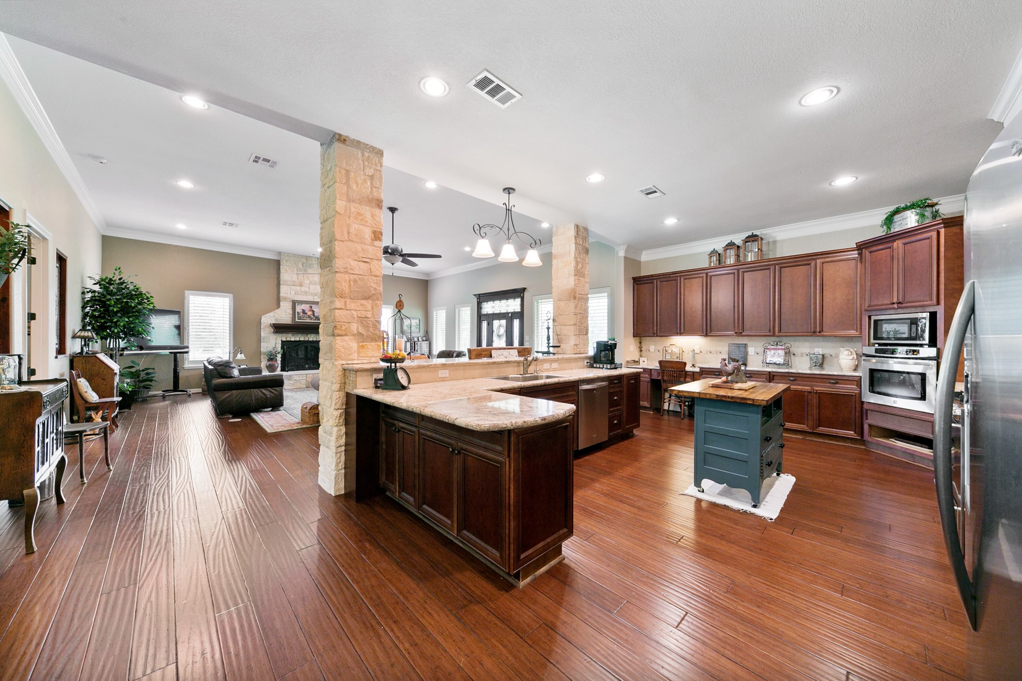 923 Y U Jones Road Richmond, TX 77469 - Photo 22 of 50 a kitchen with counter top space wooden floor and stainless steel appliances