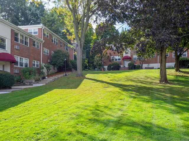 a view of a house with a big yard and large trees