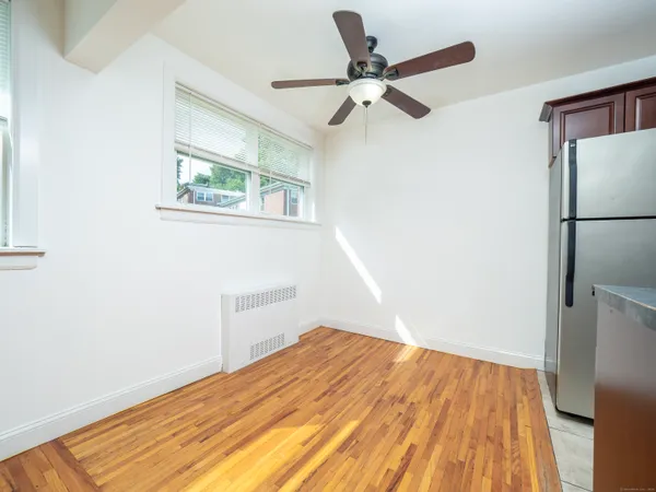 a view of a room with wooden floor and a ceiling fan