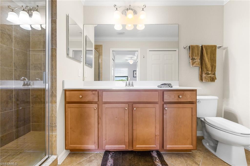 9727 Acqua Court, Unit 421 Naples, FL 34113 - Photo 17 of 35 a bathroom with a sink a toilet and shower