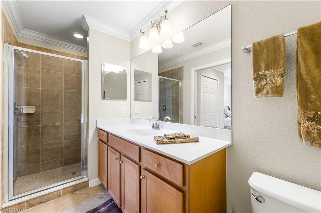 9727 Acqua Court, Unit 421 Naples, FL 34113 - Photo 18 of 35 a bathroom with a sink mirror vanity and toilet