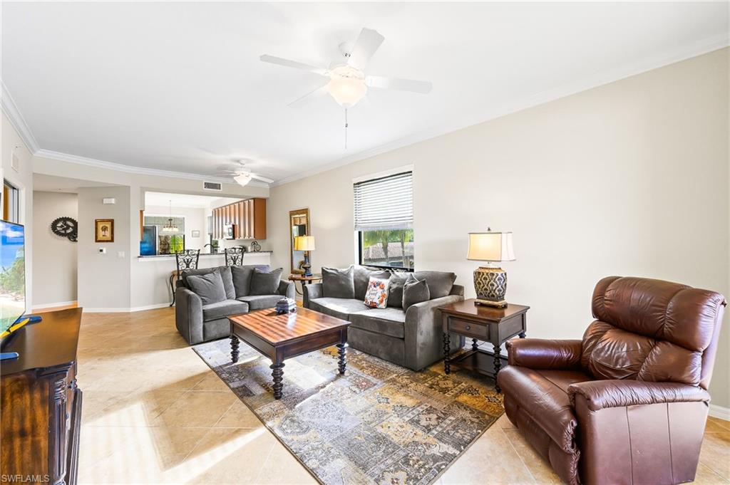 9727 Acqua Court, Unit 421 Naples, FL 34113 - Photo 2 of 35 a living room with furniture a table and a potted plant