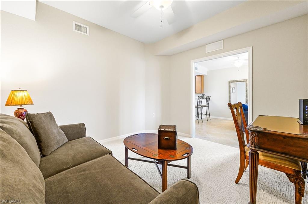 9727 Acqua Court, Unit 421 Naples, FL 34113 - Photo 23 of 35 a living room with furniture and a wooden floor