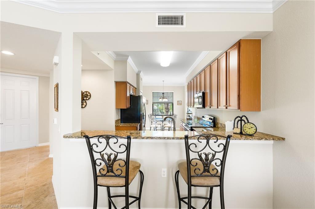 9727 Acqua Court, Unit 421 Naples, FL 34113 - Photo 6 of 35 a view of a dining room with furniture and a potted plant