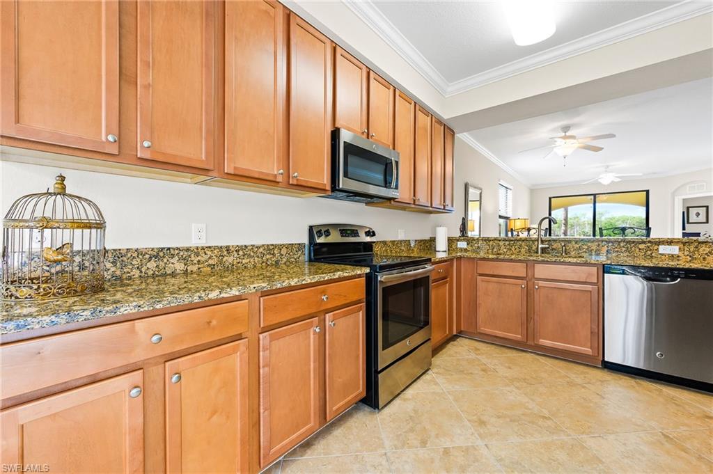 9727 Acqua Court, Unit 421 Naples, FL 34113 - Photo 8 of 35 a kitchen with stainless steel appliances granite countertop a stove sink and cabinets
