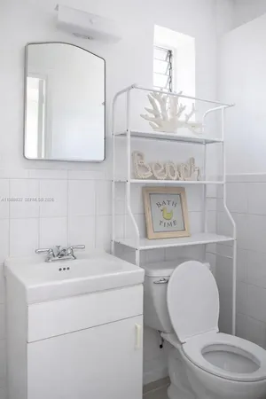 a bathroom with a toilet a sink and mirror