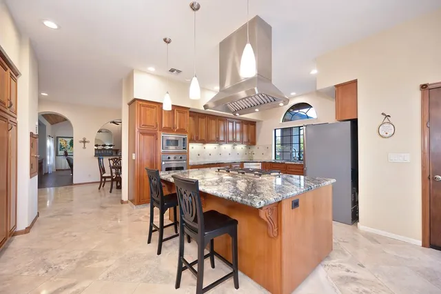 a kitchen with stainless steel appliances granite countertop a refrigerator and a stove