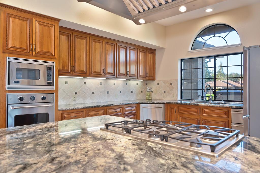 14965 Anillo Way Rancho Murieta, CA 95683 - Photo 13 of 59 a kitchen with stainless steel appliances a stove a sink and a microwave