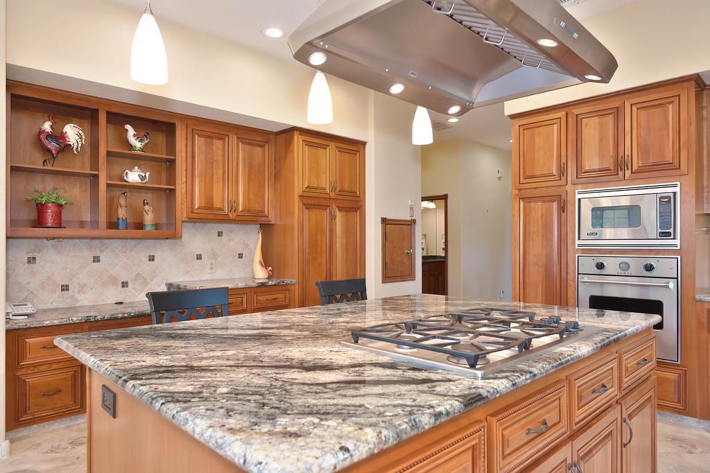 14965 Anillo Way Rancho Murieta, CA 95683 - Photo 14 of 59 a kitchen with kitchen island granite countertop a stove cabinets and refrigerator