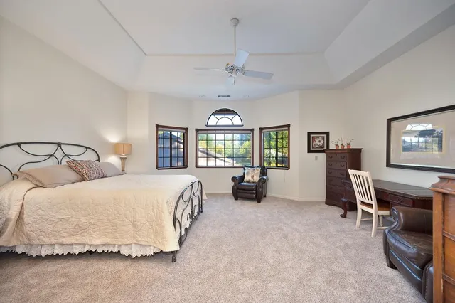a spacious bedroom with a bed and a painting on the wall