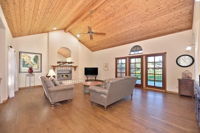 a living room with furniture a fireplace and a large window