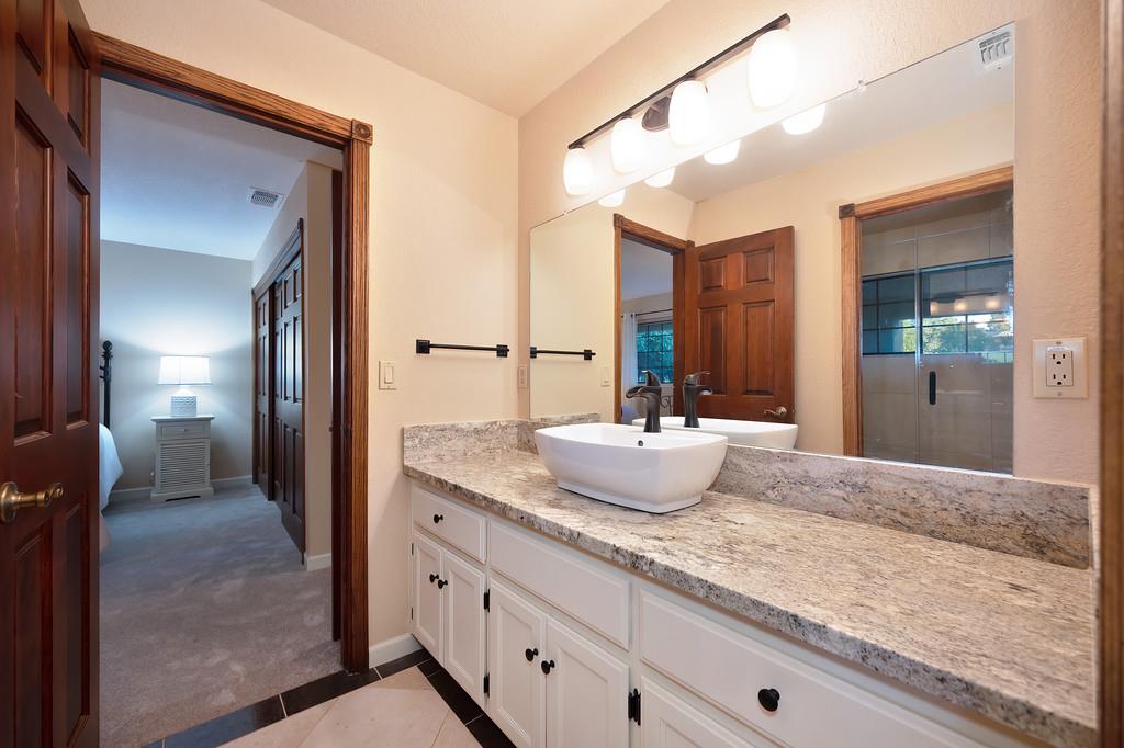 14965 Anillo Way Rancho Murieta, CA 95683 - Photo 33 of 59 a bathroom with a granite countertop sink and a mirror