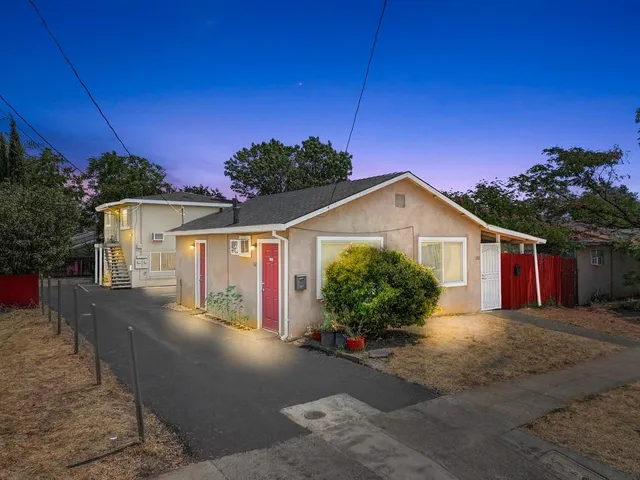 a front view of a house with a yard and potted plants