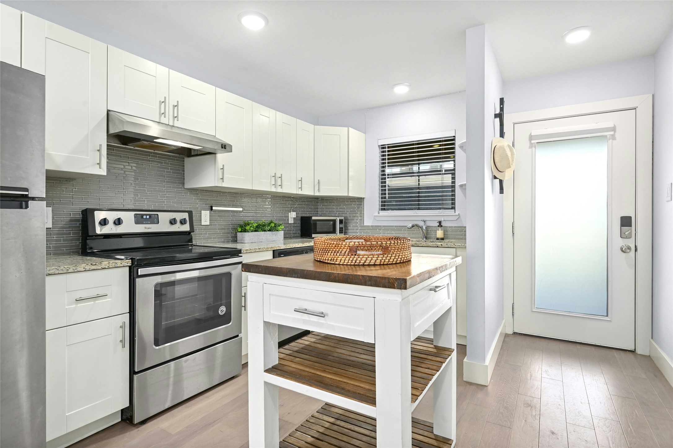909 Reinli Street, Unit 228 Austin, TX 78751 - Photo 4 of 27 a kitchen with granite countertop wooden cabinets and white appliances
