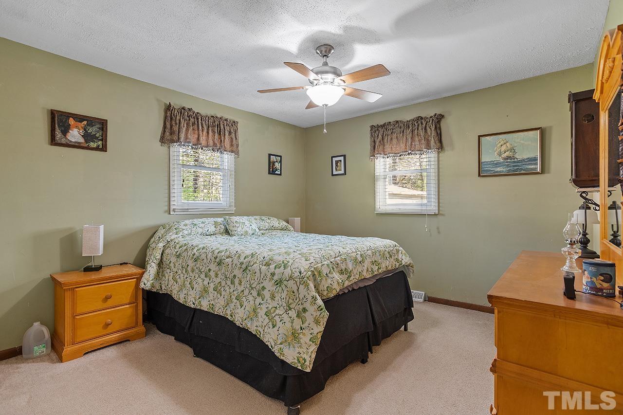 2820 Willow Court Raleigh, NC 27610 - Photo 18 of 33 a bedroom with a bed and a chandelier