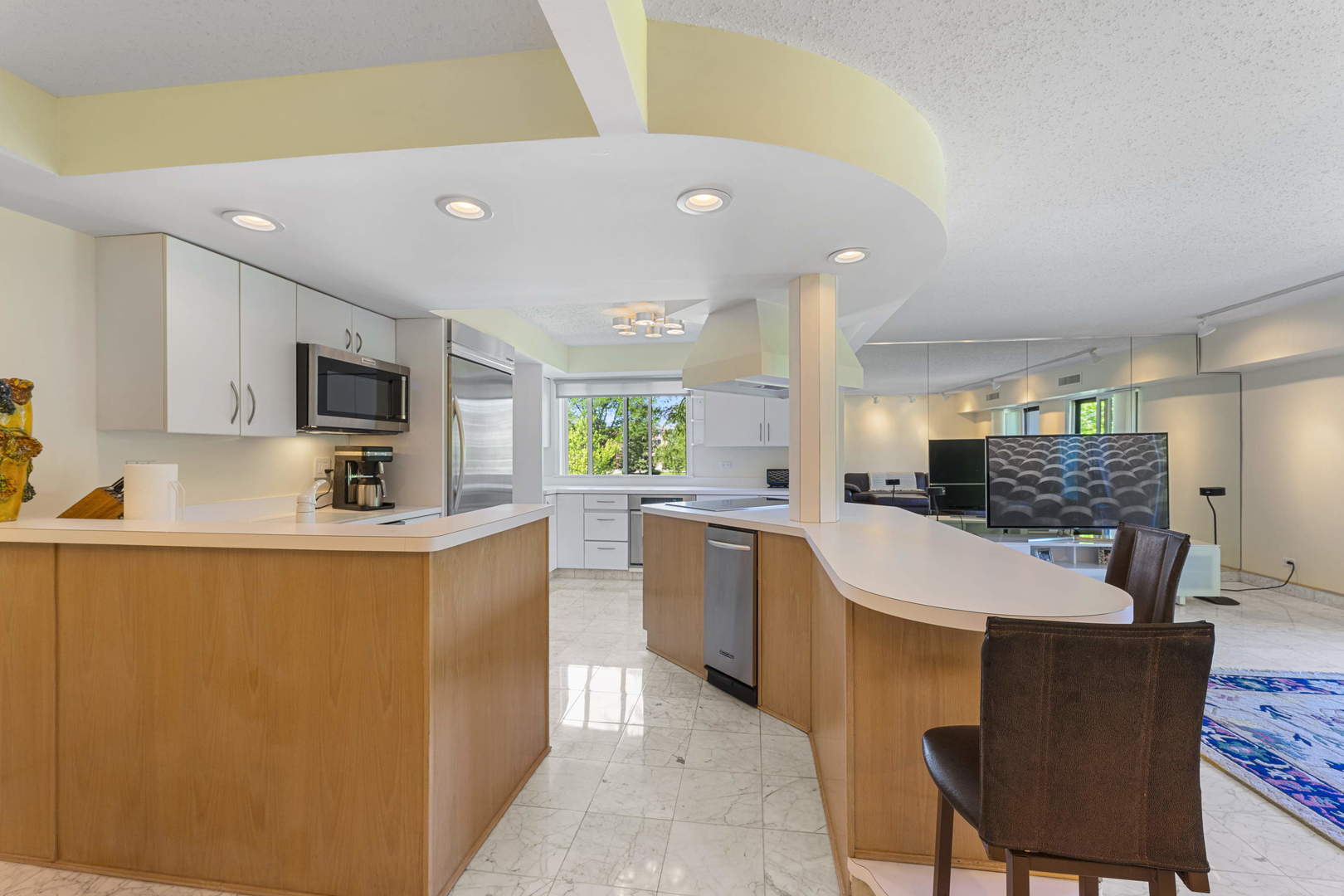 1615 East Central Road, Unit 222C Arlington Heights, IL 60005 - Photo 3 of 30 a large kitchen with stainless steel appliances kitchen island granite countertop a sink a stove a dining table and chairs