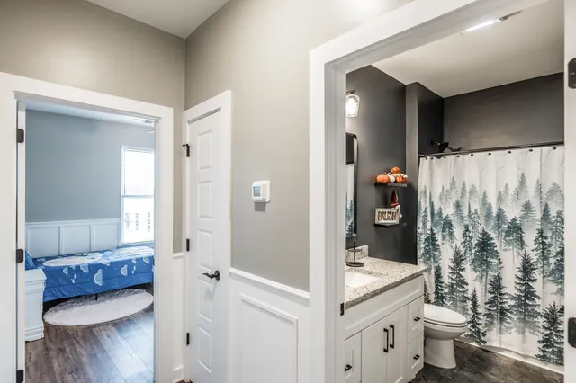 a view of an empty room with a chandelier fan