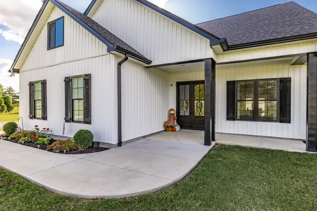 a view of a house with potted plants and a pathway