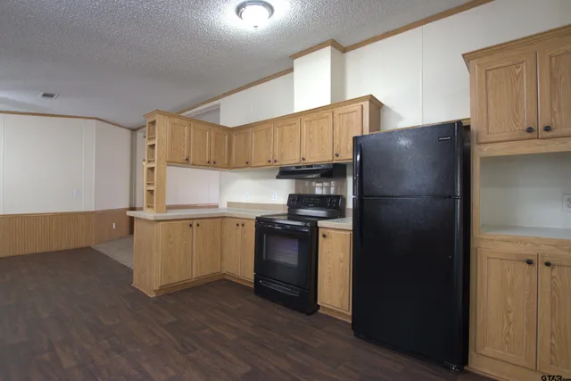 a kitchen with a refrigerator and a stove top oven