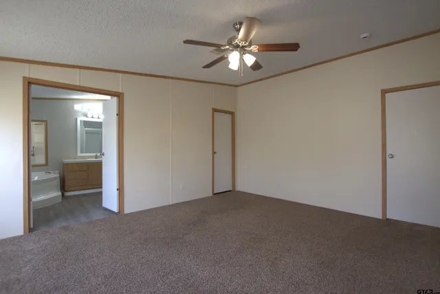 a view of an empty room with a chandelier fan