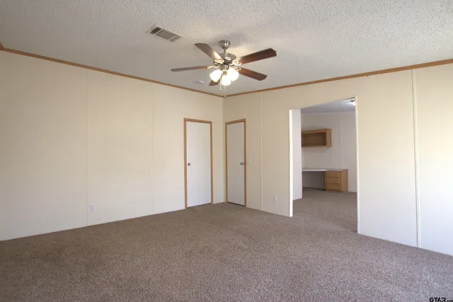 a view of an empty room and a ceiling fan