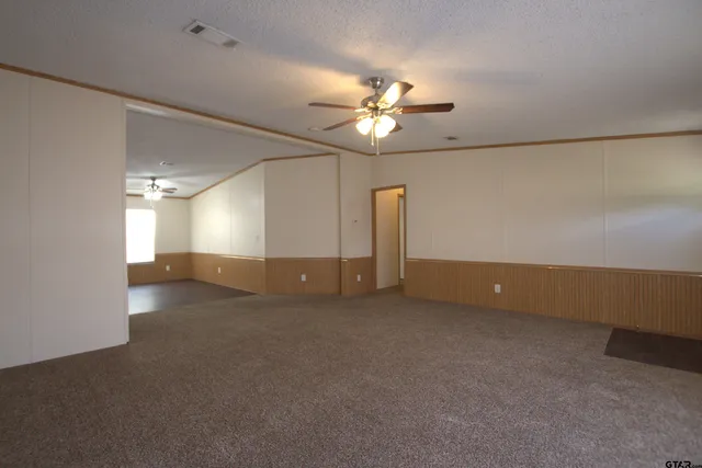an empty room with a empty space and a ceiling fan