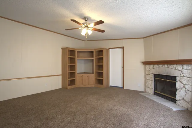 a view of an empty room with a fireplace and a window