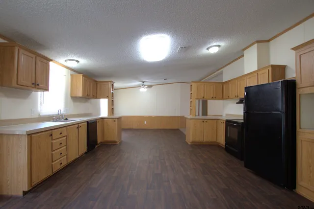 a kitchen with stainless steel appliances a refrigerator and wooden floor