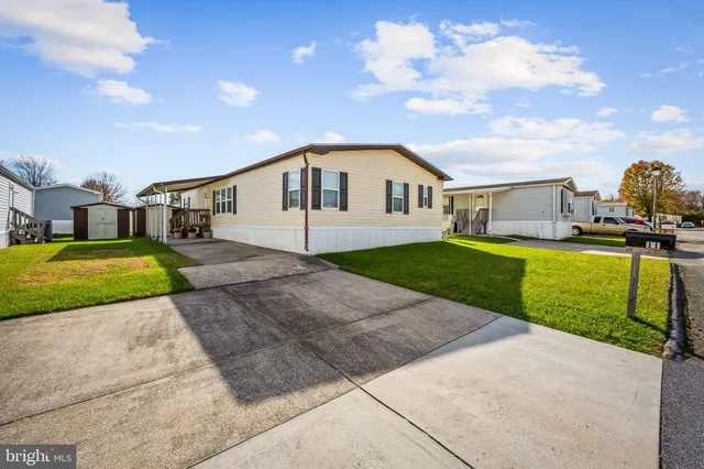 a view of a house with a yard and pathway