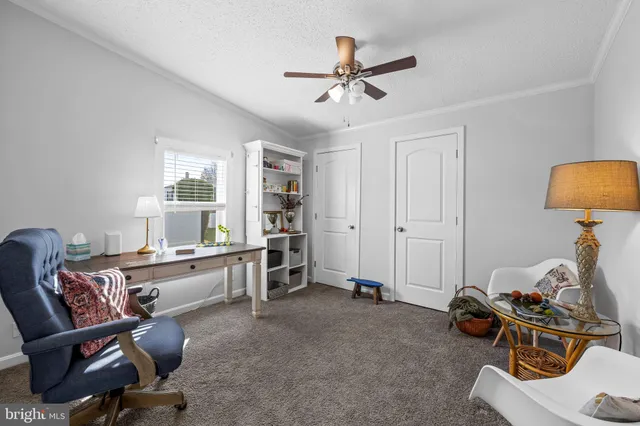 a view of a workspace with furniture and a window