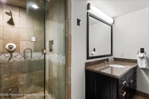 a bathroom with a sink vanity granite and a mirror