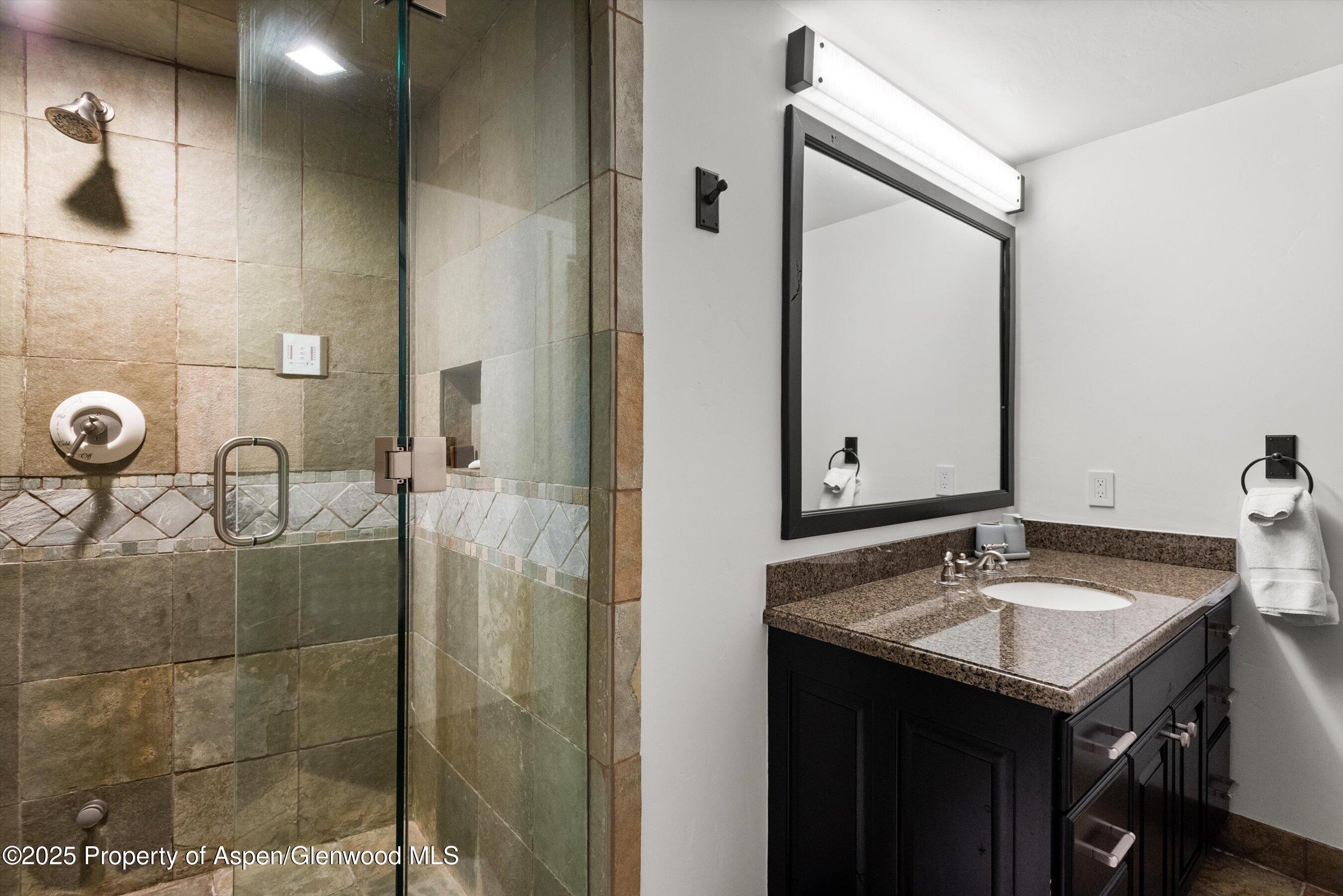 289 Exhibition Lane Aspen, CO 81611 - Photo 23 of 46 a bathroom with a sink vanity granite and a mirror