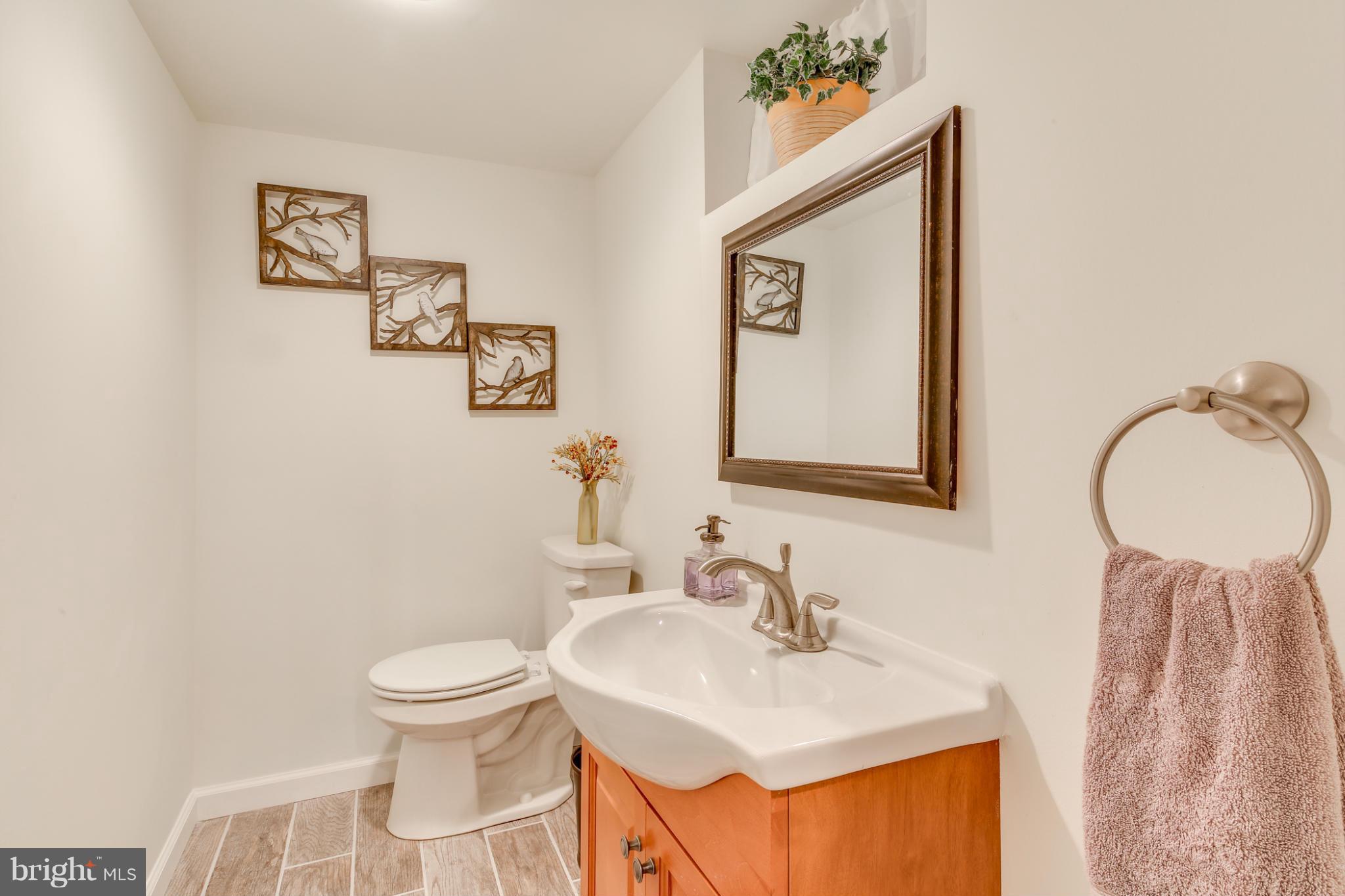 1313 Asbury Road Baltimore, MD 21209 - Photo 25 of 30 a bathroom with a sink mirror and toilet