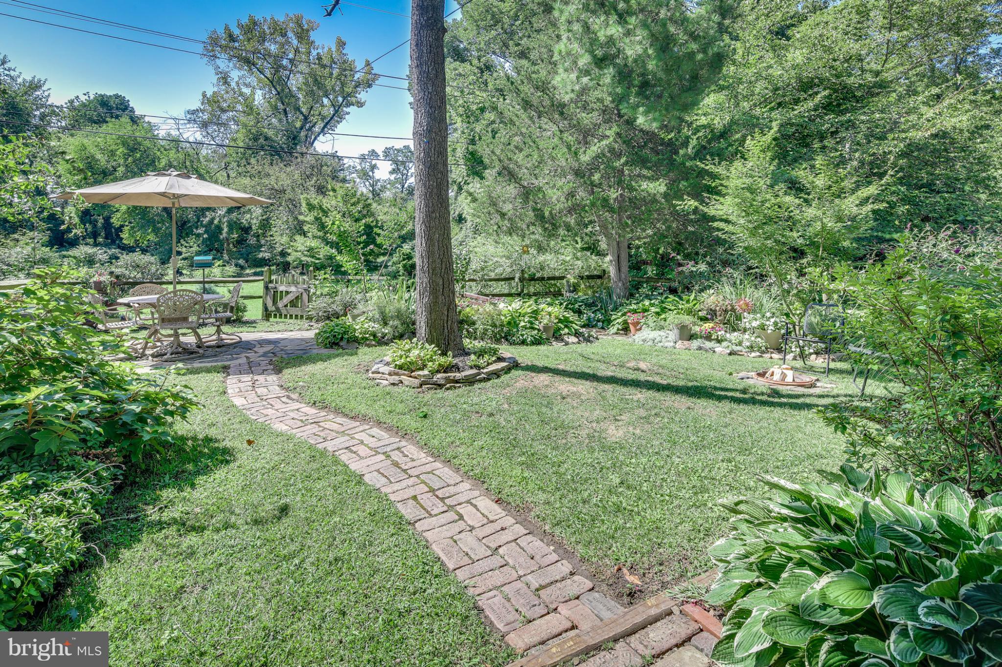 1313 Asbury Road Baltimore, MD 21209 - Photo 28 of 30 a view of a garden with a table and chairs under an umbrella
