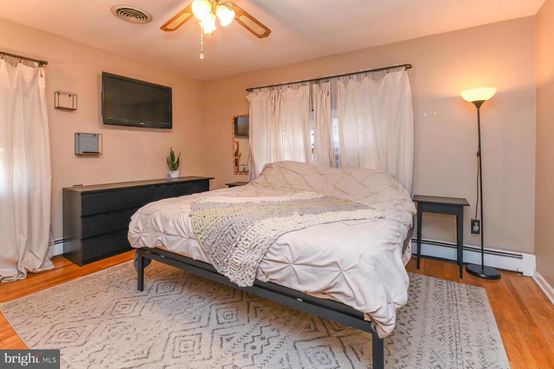 111 Atkins Avenue Hamilton, NJ 08610 - Photo 8 of 11 a bedroom with a bed and a flat tv screen on dresser