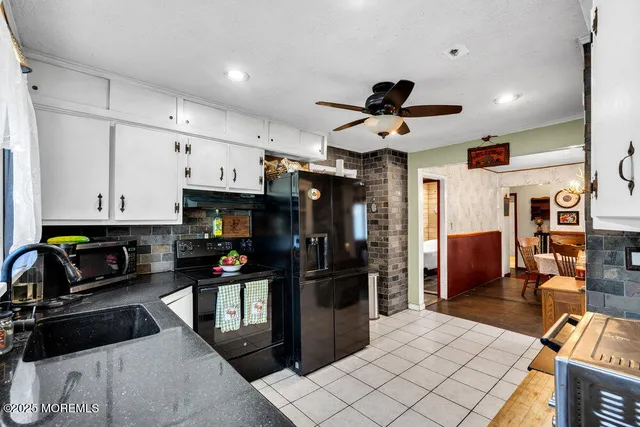 a kitchen with stainless steel appliances kitchen island granite countertop a refrigerator and a stove top oven