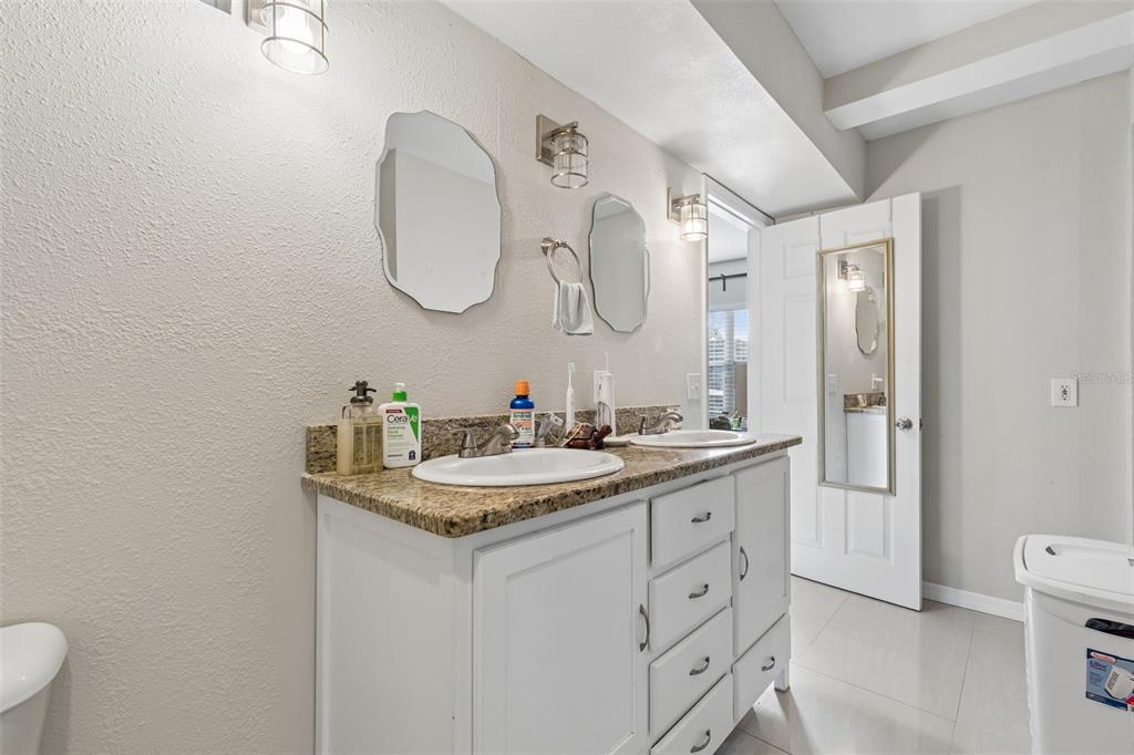 2301 West Eldred Drive Tampa, FL 33603 - Photo 25 of 34 a bathroom with a granite countertop sink a toilet and a mirror