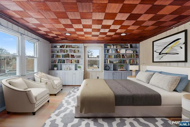 a spacious bedroom with a bed a couch and a large window