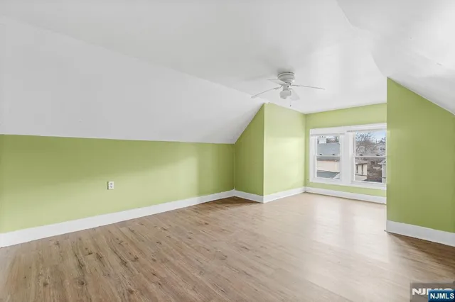 a view of a room with wooden floor and a ceiling fan