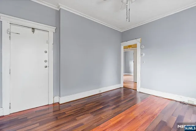 a view of an empty room with wooden floor