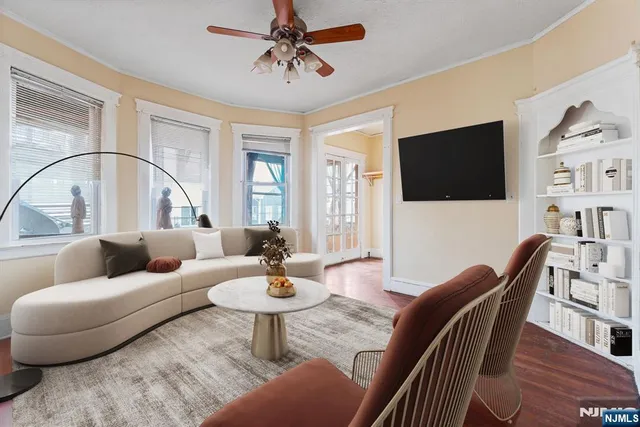 a living room with furniture a flat screen tv and a large window