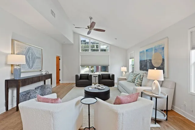 a living room with furniture kitchen view and a large window