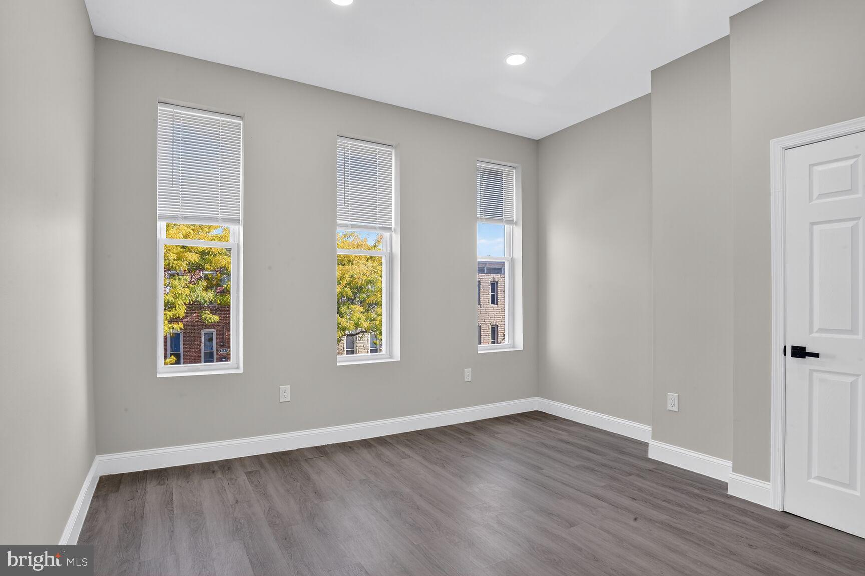 1106 South Carey Street Baltimore, MD 21223 - Photo 11 of 24 an empty room with wooden floor and windows
