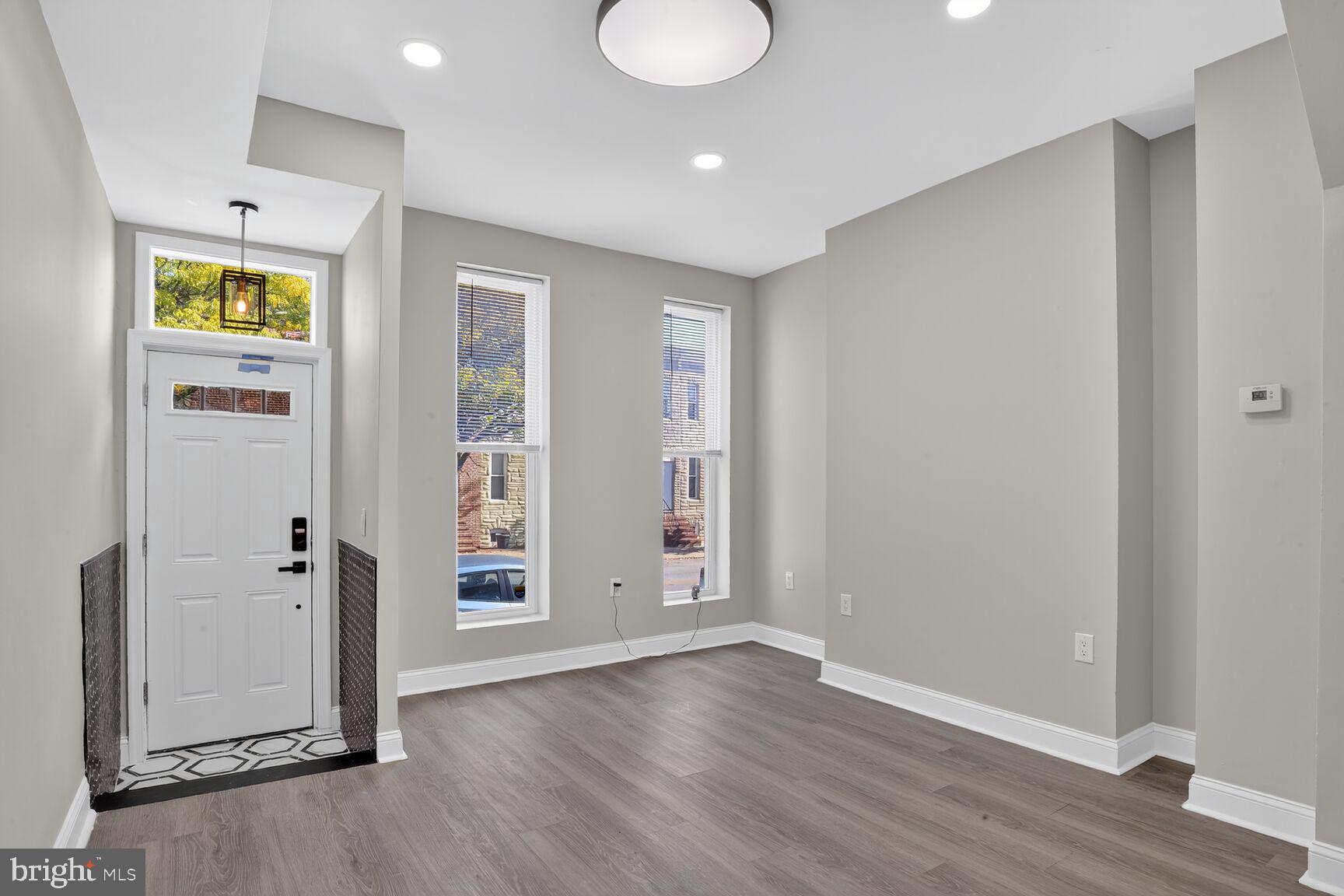 1106 South Carey Street Baltimore, MD 21223 - Photo 6 of 24 an empty room with wooden floor and windows